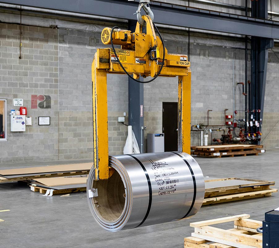 Grua alçant un cilindre en una empresa d'instal·lacions industrials i muntatges
